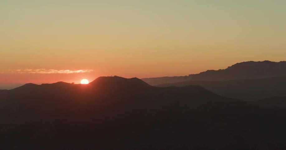 Landscape of mountains by the sea with the sunrise on the horizon