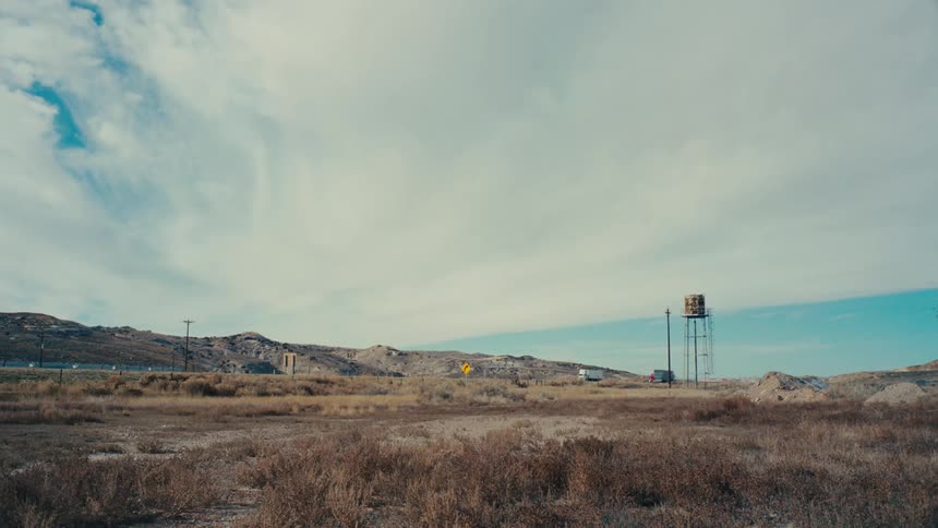 Cloudy sky over a dry desert landscape with mountains in the background