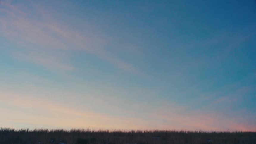Truck passing through a natural environment on a blue and pink sky day