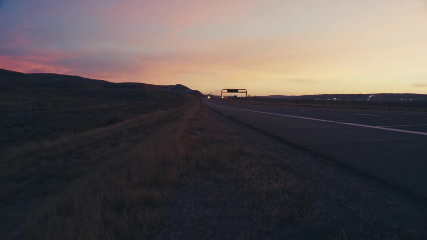 Highway at dawn with vehicle traffic and mountains in the background