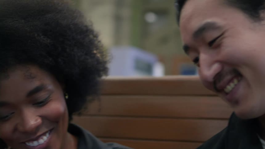 Man and woman sitting side by side and both happy