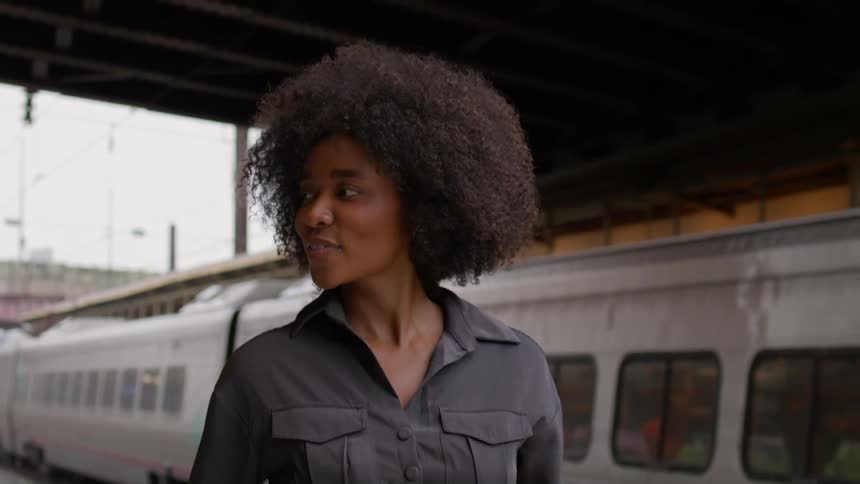 A woman walking on the train station near a parked train