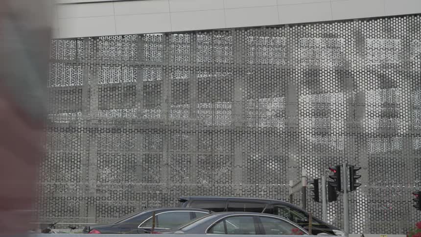 A bus driving by a fence in a city