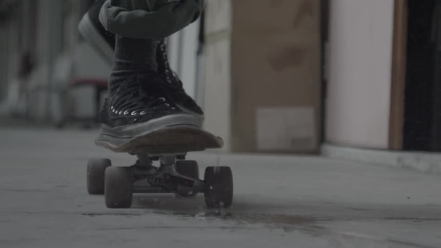 A skateboarder is hopping on his skateboard