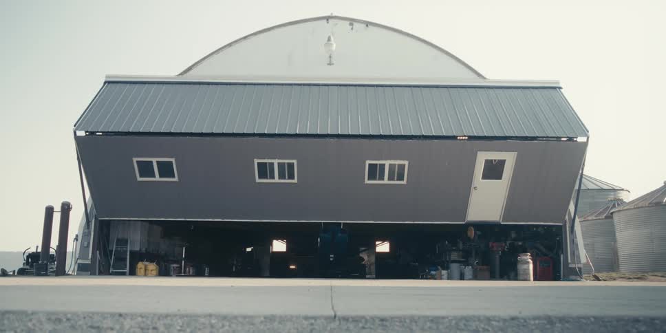 Farm Hangar door opening to reveal a parked plane inside