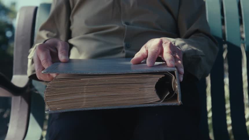 A man looks at photographs in the album
