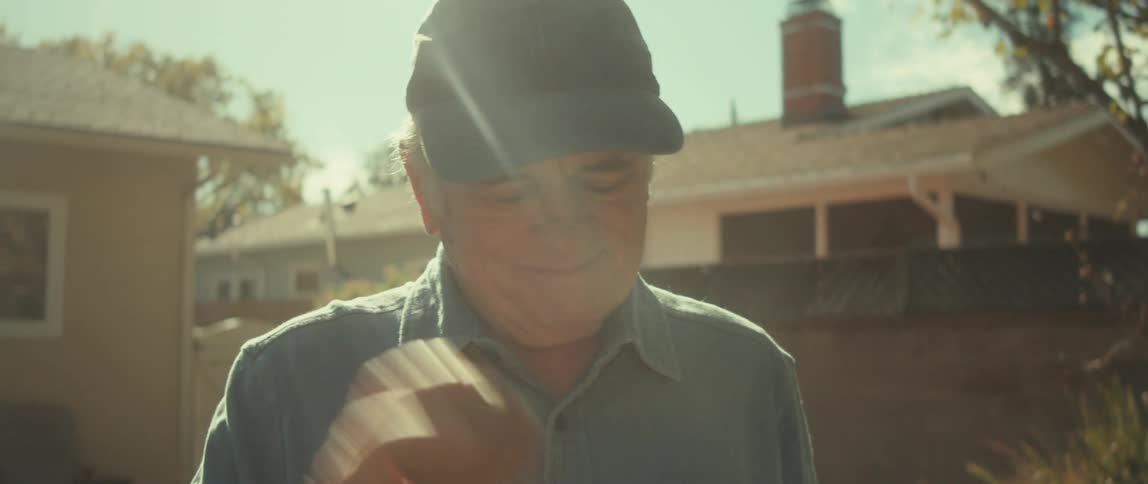 Happy senior man holding a baseball glove and ball