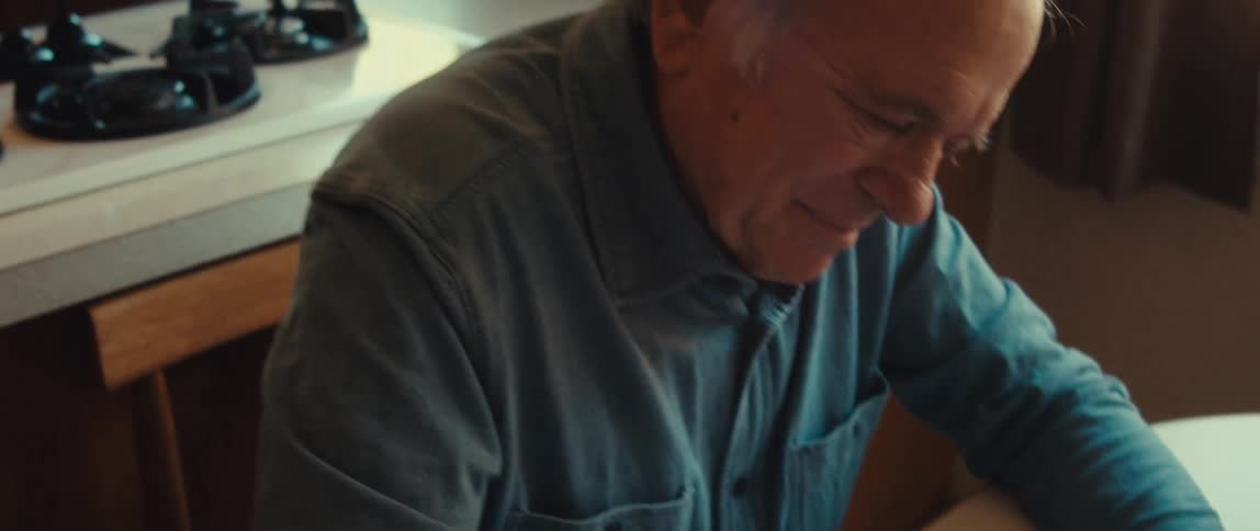 Elderly man sitting writing a letter
