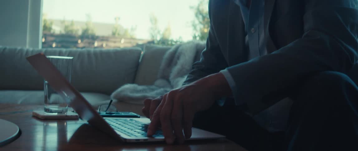 A man is using the track pad on his laptop