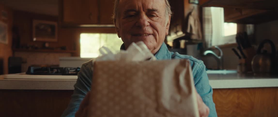 A man displays a gift in his hands