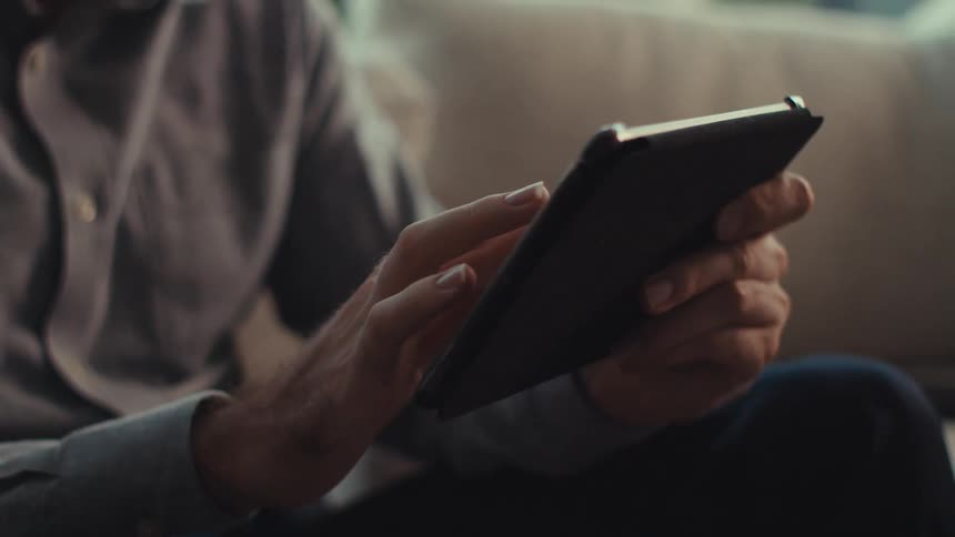 A man is tapping the screen on his tablet