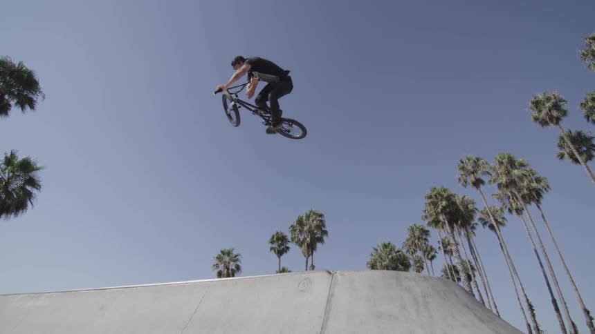 A bicyclist jumps on a ramp in a skate park