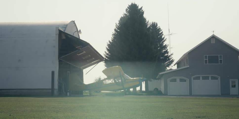 A man pulls his plane into the hangar