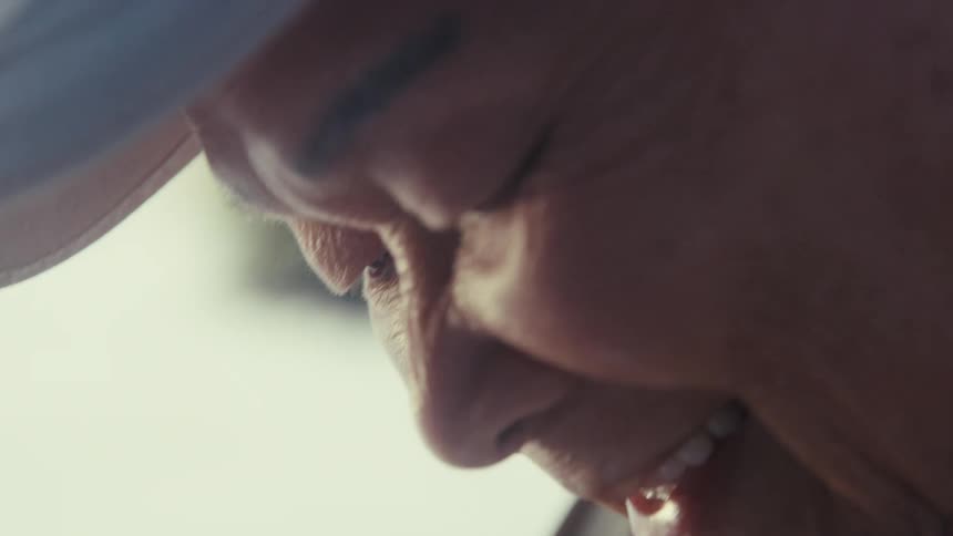 Close up of the face of an elderly asian man talking