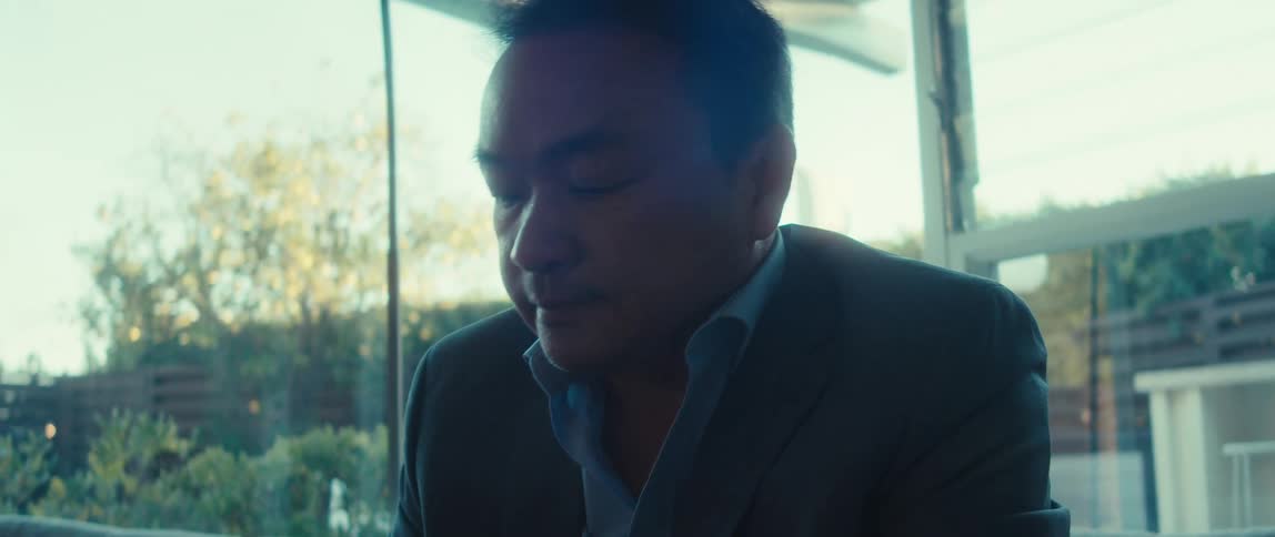 Man in blazer sitting interacting with a smartphone