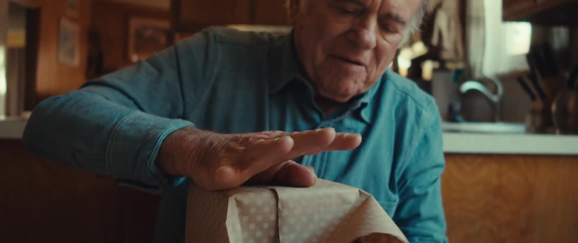 Elderly man putting a gift wrap in a box