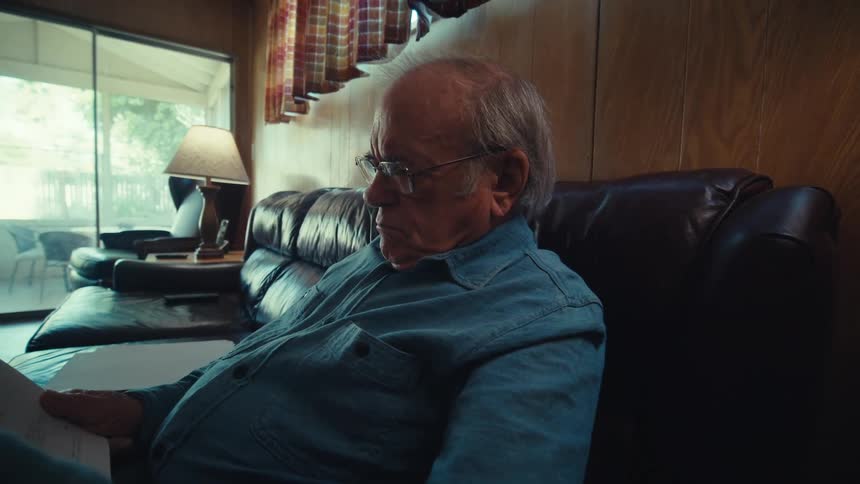 A man is reading papers at home