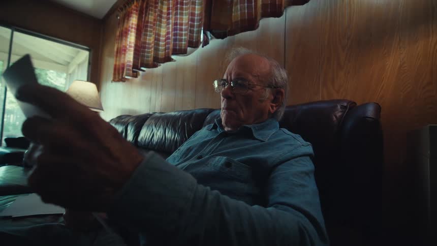 A man examines papers at home