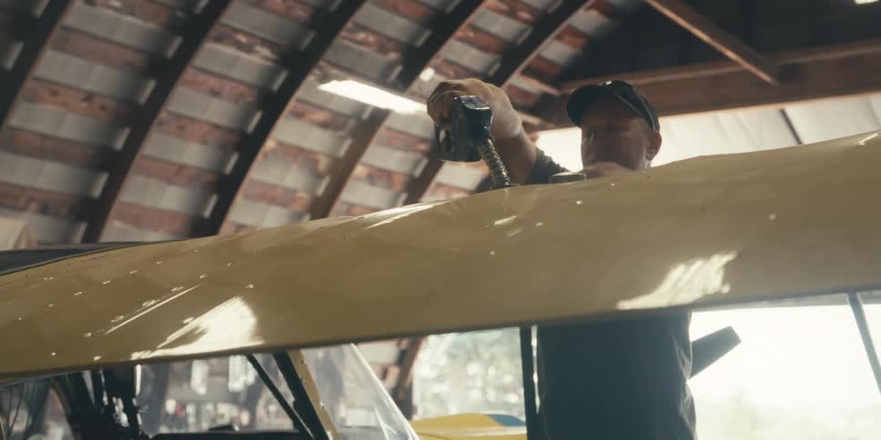 Man refueling a plane from the wing