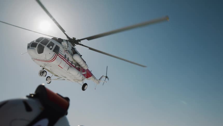 A helicopter flies through the sky