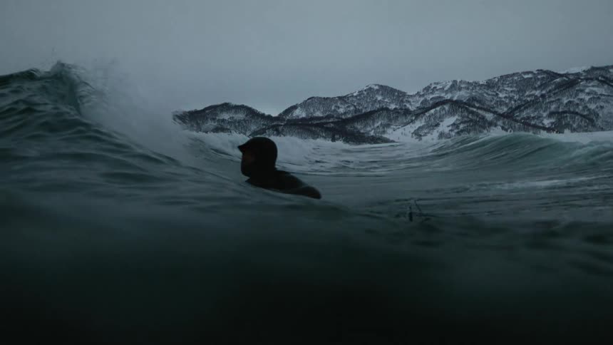 A surfer climbs a wave