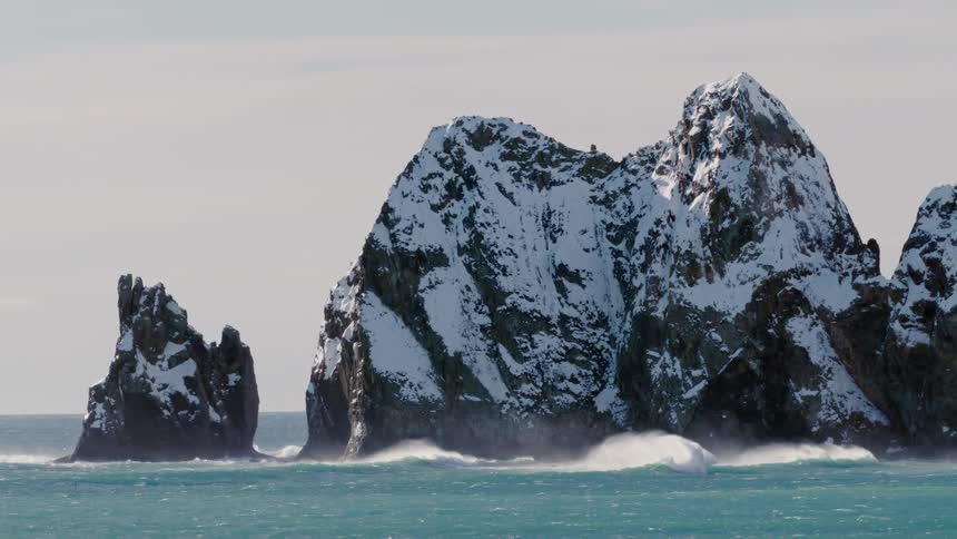 Snowcapped rocky mountains in the middle of the ocean