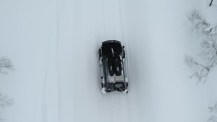 A car drives through the snow