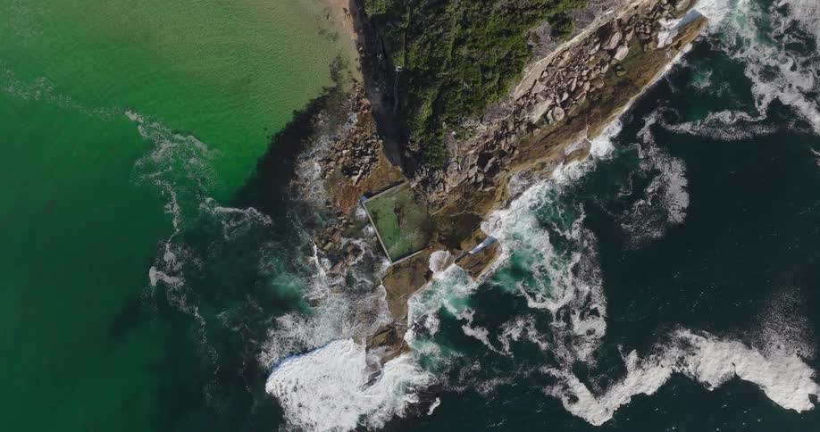 A very tall cliff faces the ocean