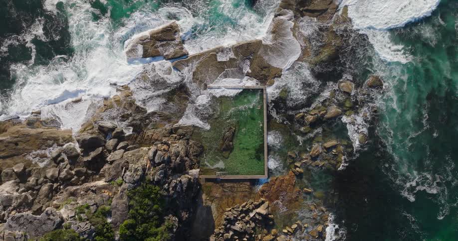 The waves crash on the rocks of the island