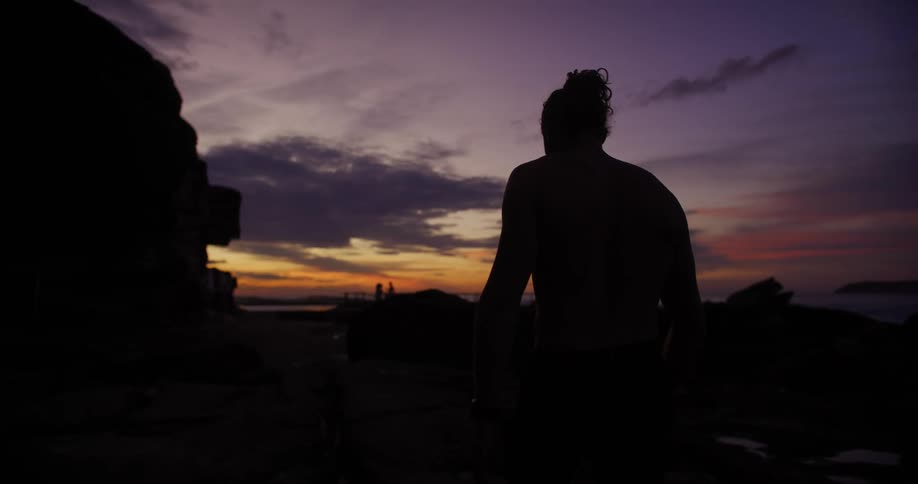 A man is hiking in the dark at sunrise