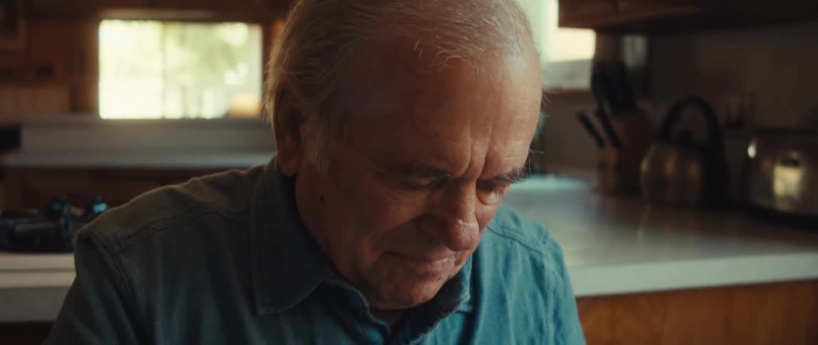 A man fiddles with a present at the table