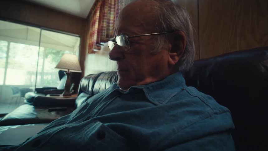 Elderly man sitting reading a document