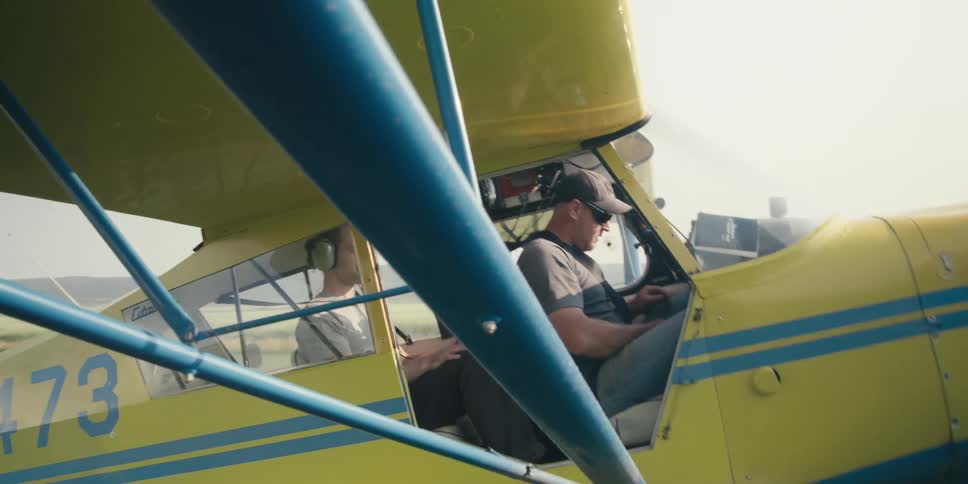 A pilot puts on his seatbelt in the plane
