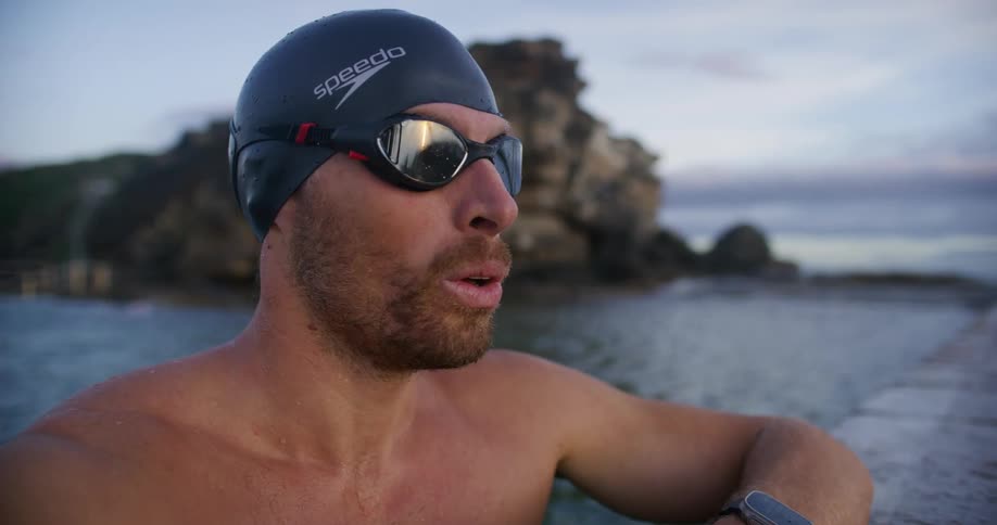 A man breaths in and out in the water