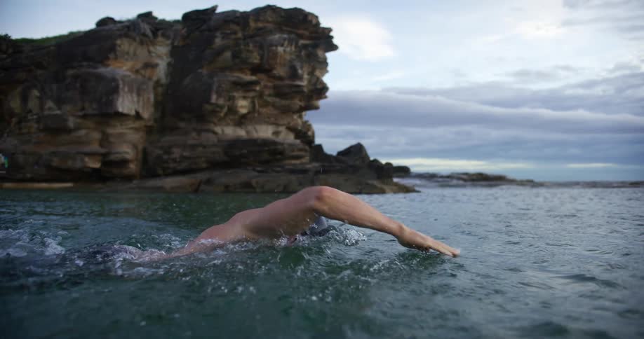 Slow motion footage of a man swimming in a body of water