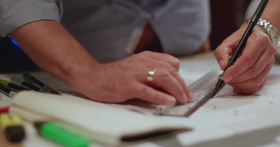A man is using a ruler to draw a diagram