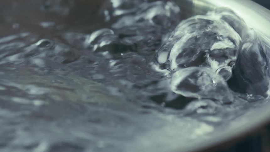 Water boiling vigorously in a pot