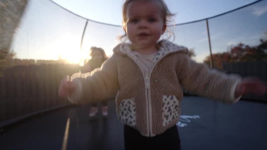 Two little girls jumping and having fun on the trampoline