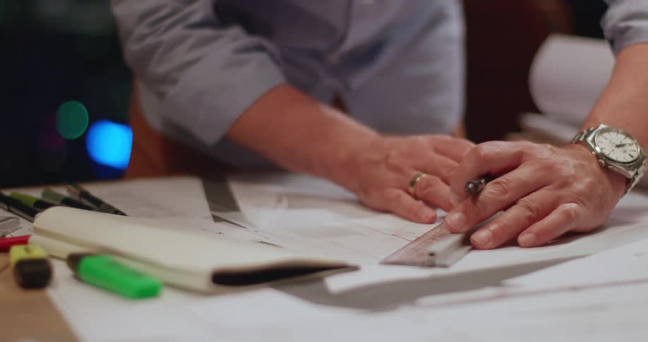 Pair of hands drawing a design with a ruler