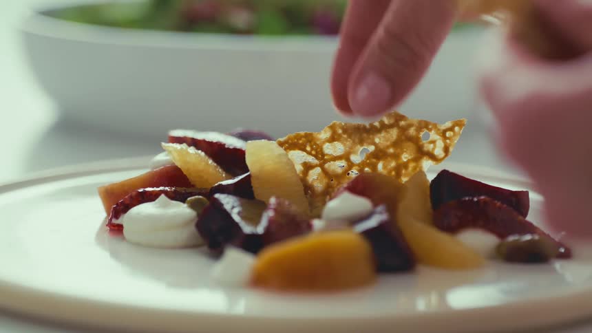 A delicate arrangement of colorful beets and fruits is adorned with a delicate crumble ready to be presented