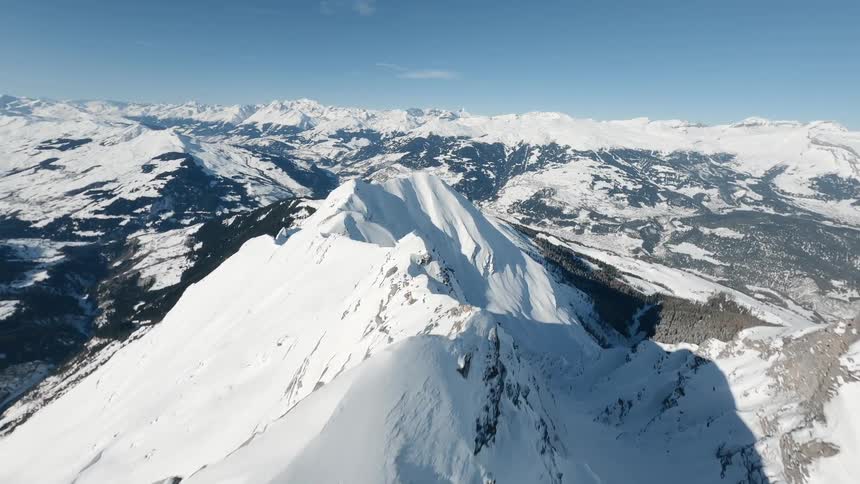 An aerial view of a snow covered mountain range with sharp peaks and valleys in Switzerland