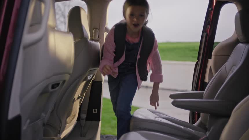 Two children getting into the car together with a dog