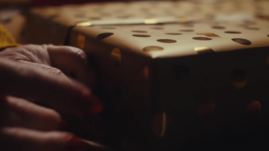 Hands wrapping a gift with a package