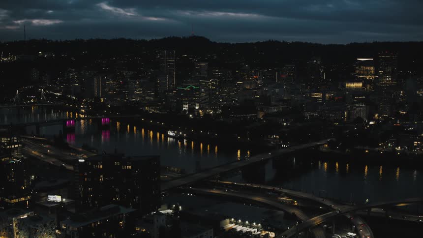 A nighttime aerial view of a city with illuminated streets and buildings