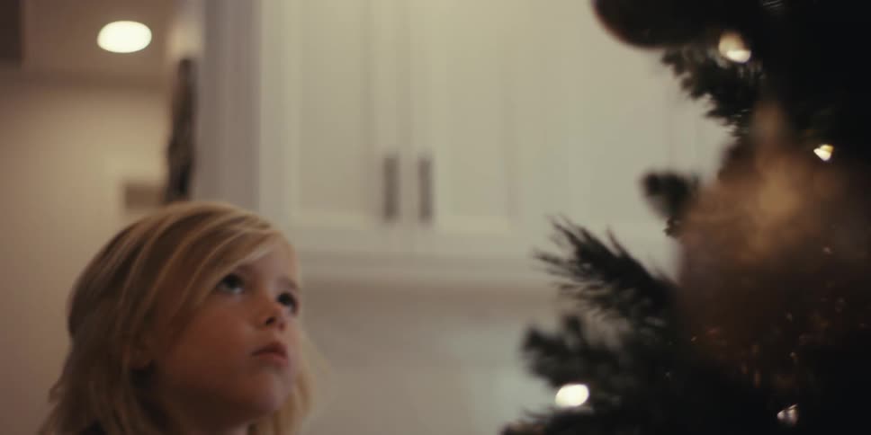 A clip of a young girl decorating a christmas tree