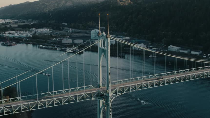 A huge suspension bridge that passes over a large body of water in a huge city