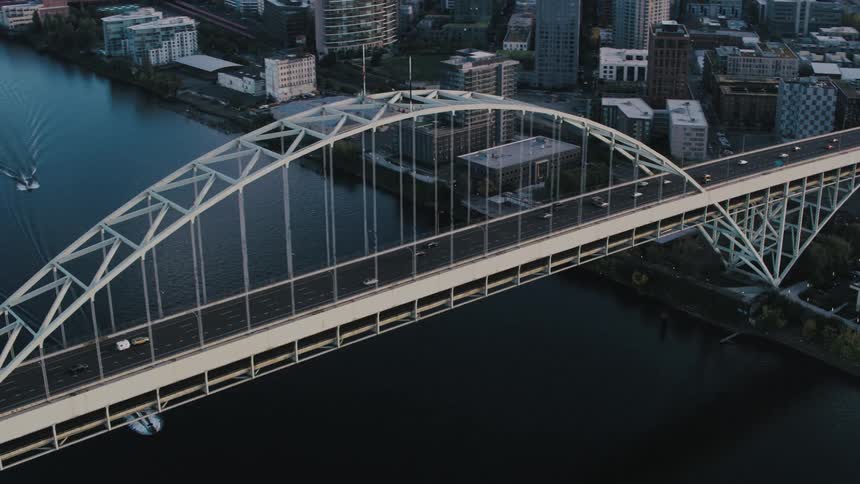 The fremont bridge arches over the willamette river carrying traffic across the waterway with its elegant steel structure