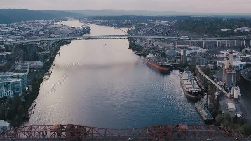 Aerial view of a sea canal surrounded by an urban city with mountains on the horizon