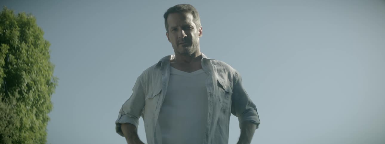 A man looks down with his hands on his hips