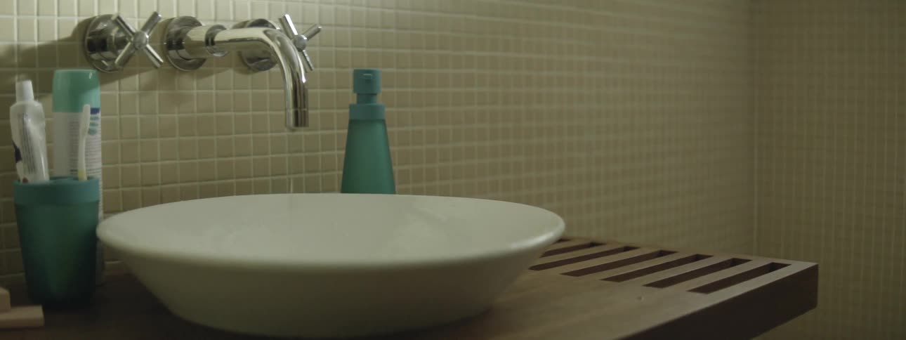 A faucet is slowly dripping water into a bowl